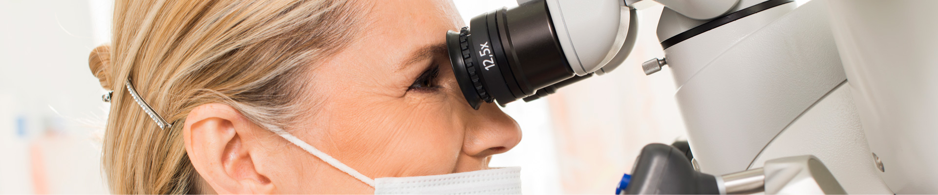 Die Zahnärztin Dr. Anna Lechner blickt durch das OP-Mikroskop