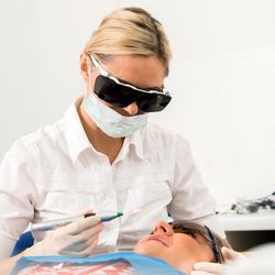 Die Zahnärztin während der Behandlung mit dem Laser